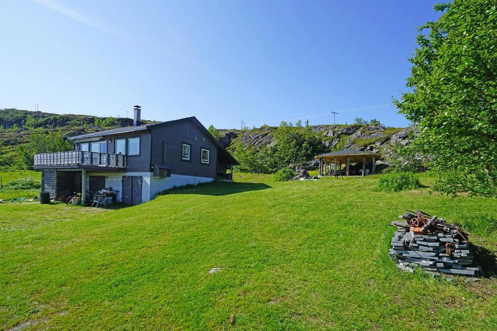 Hovedhuset - Tradisjonelt norsk hus i rolige omgivelser, omgitt av fjell og fjord.